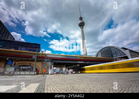 Berlin - 23. Juni 2024: Bahnhof Alexanderplatz. Fernsehturm im Hintergrund. Sonniger Tag, mittelbewölkter Himmel. Stockfoto