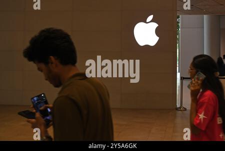 Mumbai, Indien. September 2024. Die Leute laufen am Apple Logo in der Nähe des Apple Stores im Bandra Kurla Complex (BKC) in Mumbai vorbei. Die Kunden standen in einer langen Warteschlange, um die neue iPhone 16-Serie zu überprüfen und zu kaufen, die am 20. September 2024 in den Handel kam. Quelle: SOPA Images Limited/Alamy Live News Stockfoto