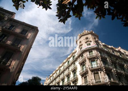 Die historische Architektur des Carrer Gran de Gracia zeigt komplexe Details vor einem leuchtend blauen Himmel im Stadtteil Gracia. Stockfoto