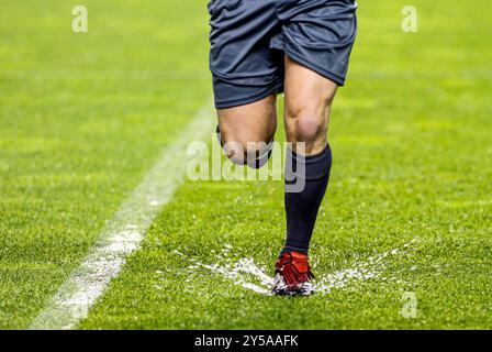 Der Schiedsrichter navigiert während eines Spiels auf einem überfluteten Feld Stockfoto