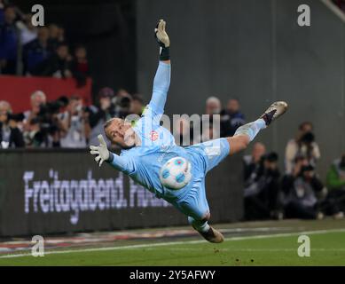 Augsburg, Deutschland. September 2024. Mainzer Torhüter Robin Zentner versucht, den Ball beim Fußball-Spiel der ersten Bundesliga zwischen dem FC Augsburg und dem FSV Mainz 05 in Augsburg am 20. September 2024 zu retten. Quelle: Philippe Ruiz/Xinhua/Alamy Live News Stockfoto