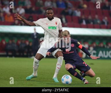 Augsburg, Deutschland. September 2024. Ogochukwu Frank Onyeka (L) aus Augsburg streitet mit Jonathan Michael Burkardt aus Mainz während des Fußballspiels der ersten Bundesliga zwischen dem FC Augsburg und dem FSV Mainz 05 in Augsburg, Deutschland, 20. September 2024. Quelle: Philippe Ruiz/Xinhua/Alamy Live News Stockfoto