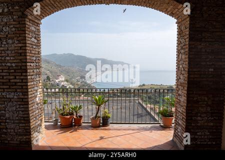 Taormina, Italien - 19. Juni 2024: Blick auf das Meer und die Berge, umrahmt von einem Bogen. Stockfoto