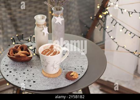 Cappuccino-Keramik-Tasse und Tischdekoration. Weihnachtsfeiern. Hintergrund für die Konstruktion. Stockfoto