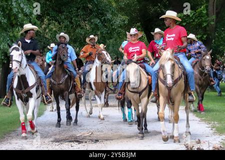 Cowboys, Cowgirls und ihre Pferde beginnen ihren 7,5 Meilen (12 km) langen Ritt durch mehrere Viertel Chicagos zum Lakefront während des 33. Jährlichen High Noon Ride auf Chicagos South Side. Dies ist eine Wiedervereinigung der Chicago’s Black Cowboys, die seit 1989 vom Broken Arrow Riding Club organisiert wird. USA. Stockfoto