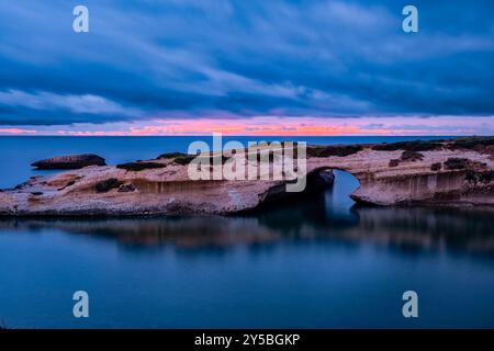 Arco di S Archittu, ein 17 Meter hoher Felsbogen, das Ergebnis der Meereserosion einer alten Höhle, die sich im Kalkstein gebildet hat, bei Sonnenuntergang. S Archittu Sardinien Stockfoto