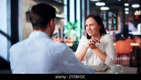 Lachende Männer Und Frauen Sitzen Im Café, Trinken Kaffee Und Reden Stockfoto