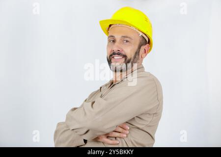 Der Techniker trägt einen gelben Helm mit überkreuztem Arm Stockfoto