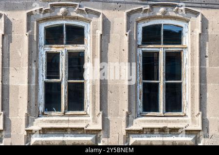 Zwei Fenster in einem alten Wohnhaus aus Tuffstein in Gyumri Stadt, Armenien an sonnigen Sommertagen Stockfoto