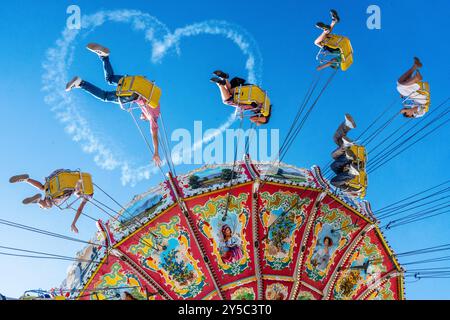 Wiesnherz am blauen Himmel, Kettenkarussel Wellenflug mit der ersten Fahrt, Start des Oktoberfests 2024 bei Sonnenschein, 21. September 2024 Deutschland, München, 21.09.2024, Wiesnherz am blauen Himmel, Kettenkarussel Wellenflug mit der ersten Fahrt, Start des Oktoberfests 2024 bei Sonnenschein, Eröffnungstag mittags um kurz nach 12 Uhr, Kunstflieger Sascha Odermann hat wieder einen Wiesngruß in den Himmel geschickt, bestes Wiesnwetter, typisch bayerisch, Volksfest, Bayern, *** Wiesnherz am blauen Himmel, Kettenkarussell Wellenflug mit der ersten Fahrt, Beginn des Oktoberfestes 2024 bei Sonnenschein, Stockfoto