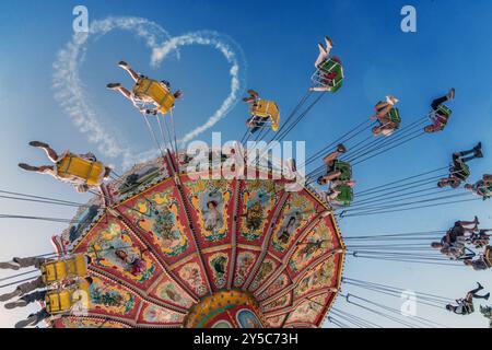 Wiesnherz am blauen Himmel, Kettenkarussel Wellenflug bei der ersten Fahrt, Start des Oktoberfests 2024 bei Sonnenschein, 21. September 2024 Deutschland, München, 21.09.2024, Wiesnherz am blauen Himmel, Kettenkarussel Wellenflug mit der ersten Fahrt, Start des Oktoberfests 2024 bei Sonnenschein, Eröffnungstag mittags um kurz nach 12 Uhr, Kunstflieger Sascha Odermann hat wieder einen Wiesngruß in den Himmel geschickt, bestes Wiesnwetter, typisch bayerisch, Volksfest, Bayern, *** Wiesnherz am blauen Himmel, Kettenkarussell Wellenflug mit der ersten Fahrt, Beginn des Oktoberfestes 2024 bei Sonnenschein, Stockfoto