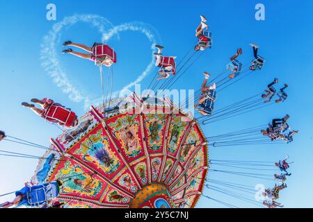 Wiesnherz am blauen Himmel, Kettenkarussel Wellenflug bei der ersten Fahrt, Start des Oktoberfests 2024 bei Sonnenschein, 21. September 2024 Deutschland, München, 21.09.2024, Wiesnherz am blauen Himmel, Kettenkarussel Wellenflug mit der ersten Fahrt, Start des Oktoberfests 2024 bei Sonnenschein, Eröffnungstag mittags um kurz nach 12 Uhr, Kunstflieger Sascha Odermann hat wieder einen Wiesngruß in den Himmel geschickt, bestes Wiesnwetter, typisch bayerisch, Volksfest, Bayern, *** Wiesnherz am blauen Himmel, Kettenkarussell Wellenflug mit der ersten Fahrt, Beginn des Oktoberfestes 2024 bei Sonnenschein, Stockfoto