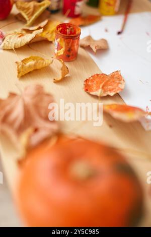 Herbstblätter mit Pinsel auf Papier auf dem Tisch, Herbstkindhintergrund Stockfoto