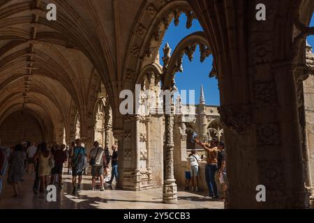 Touristen wandern auf dem Balkon des Klosters Jerónimos mit seinen komplizierten Steinschnitzereien, dem Nationaldenkmal und dem UNESCO-Weltkulturerbe. Stockfoto