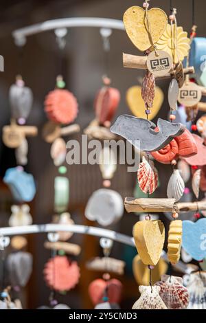 Dekorative bunte Windspiele und Handys hängen an einem Stand in einem Touristengeschäft in zante, zakynthos, griechenland Stockfoto