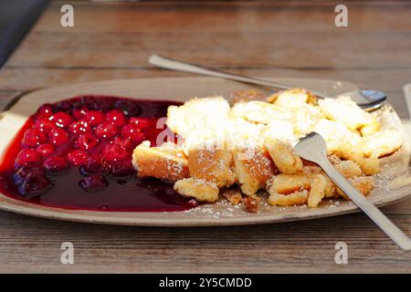 Traditioneller österreichischer hausgemachter Kaiserschmarren serviert mit Roter Grütze (süß-saure Sauce aus Beerenfrüchten ) Stockfoto