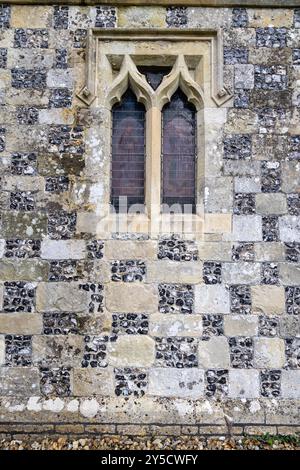 Fenster und Wand aus kariertem Feuerstein und Kalksteinmauer, Kirche St. Nikolaus von Mira, Turm Langford, Wiltshire, ein denkmalgeschütztes Gebäude. Stockfoto