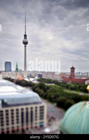 Der berühmte Fernsehturm steht hoch vor der Skyline, die von der Kuppel eines historischen Doms in Berlin erfasst wurde. Stockfoto