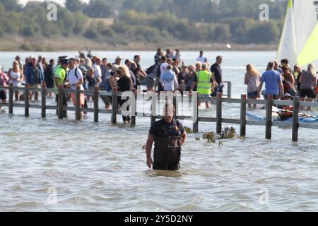 Mersea Island, Großbritannien. September 2024. Das jährliche Rennen um die Insel fand heute um Mersea Island in Essex statt. Segelschiffe aller Art nehmen an der Veranstaltung Teil. Die Besatzungen müssen ihre Boote über den Strood transportieren, der einzigen Straße auf und vor der Insel, die bei außergewöhnlich hohen Fluten überschwemmt wird. Credit:Eastern Views/Alamy Live News Stockfoto