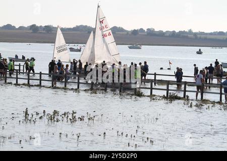 Mersea Island, Großbritannien. September 2024. Das jährliche Rennen um die Insel fand heute um Mersea Island in Essex statt. Segelschiffe aller Art nehmen an der Veranstaltung Teil. Die Besatzungen müssen ihre Boote über den Strood transportieren, der einzigen Straße auf und vor der Insel, die bei außergewöhnlich hohen Fluten überschwemmt wird. Credit:Eastern Views/Alamy Live News Stockfoto