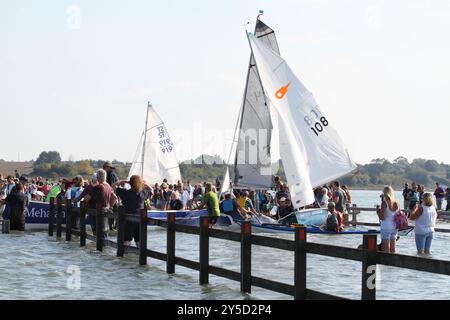 Mersea Island, Großbritannien. September 2024. Das jährliche Rennen um die Insel fand heute um Mersea Island in Essex statt. Segelschiffe aller Art nehmen an der Veranstaltung Teil. Die Besatzungen müssen ihre Boote über den Strood transportieren, der einzigen Straße auf und vor der Insel, die bei außergewöhnlich hohen Fluten überschwemmt wird. Credit:Eastern Views/Alamy Live News Stockfoto