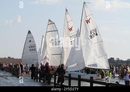 Mersea Island, Großbritannien. September 2024. Das jährliche Rennen um die Insel fand heute um Mersea Island in Essex statt. Segelschiffe aller Art nehmen an der Veranstaltung Teil. Die Besatzungen müssen ihre Boote über den Strood transportieren, der einzigen Straße auf und vor der Insel, die bei außergewöhnlich hohen Fluten überschwemmt wird. Credit:Eastern Views/Alamy Live News Stockfoto