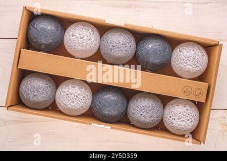 Eine elektrische, batteriebetriebene Girlande mit Diodenleuchten in einem Papierkasten, Makro, Draufsicht. Stockfoto