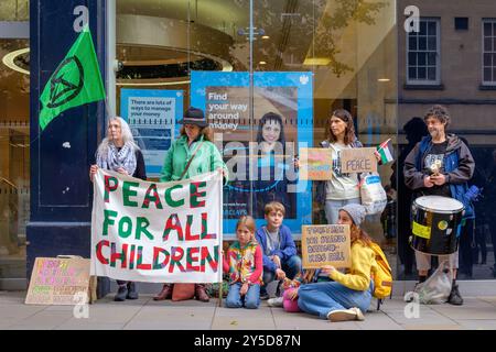 Bath, UK. September 2024. Die Demonstranten stehen vor der Barclays Bank, während sie an einem protestmarsch durch das Zentrum von Bath teilnehmen. Barclays wurde für seine Investitionen in Waffenlieferanten kritisiert. Der Protest "Kampf gegen den Klimawandel - Krieg nicht anheizen" wurde von der Extinction Rebellion Bath und der Bath-Gruppe "Stop war" organisiert und fand statt, um die Tatsache zu unterstreichen, dass Großbritannien sieben Mal so viel für Waffen ausgibt wie für den Klimawandel. Quelle: Lynchpics/Alamy Live News Stockfoto