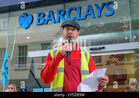 Bath, UK. September 2024. Die Demonstranten stehen vor der Barclays Bank, während sie an einem protestmarsch durch das Zentrum von Bath teilnehmen. Barclays wurde für seine Investitionen in Waffenlieferanten kritisiert. Der Protest "Kampf gegen den Klimawandel - Krieg nicht anheizen" wurde von der Extinction Rebellion Bath und der Bath-Gruppe "Stop war" organisiert und fand statt, um die Tatsache zu unterstreichen, dass Großbritannien sieben Mal so viel für Waffen ausgibt wie für den Klimawandel. Quelle: Lynchpics/Alamy Live News Stockfoto