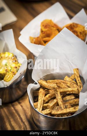 Rustikale Pommes Frites und andere einfache Snacks auf dem Tisch Stockfoto