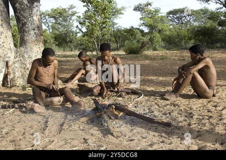 Die Buschmanenfamilie arbeitet am Feuer, Namibia, Afrika Stockfoto