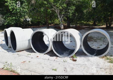 Zementrohre am Sandstrand. Stockfoto