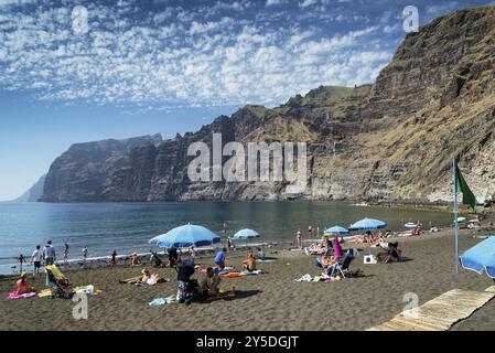 Touristen an den Klippen von los gigantes vulkanischer schwarzer Sandstrand natürliches Wahrzeichen im Süden teneriffas Insel spanien Stockfoto