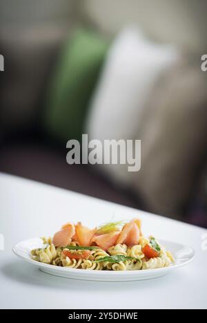 Frischer Nudelsalat mit geräuchertem Lachs aus Bio-Tomaten und Basilikum mit Ricotta-Sahnesauce und Dill Stockfoto