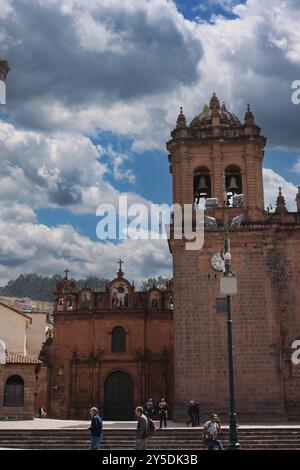 Ein Glockenturm der Kathedrale Basilika der Himmelfahrt der Jungfrau mit dem Tempel der Heiligen Familie dahinter in Cusco, Peru Stockfoto