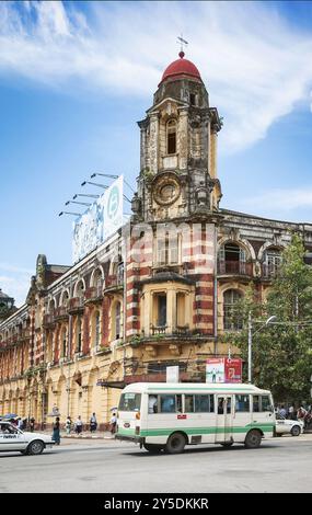 Britisches Kolonialgebäude und Stadtbus im Zentrum von yangon myanmar Stockfoto