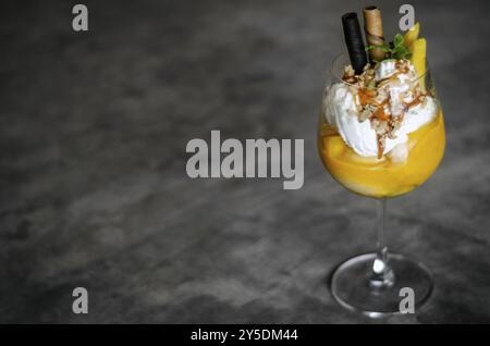 Tropische Eisbecher aus Bio-Mango und Passionsfrucht im Weinglas Stockfoto