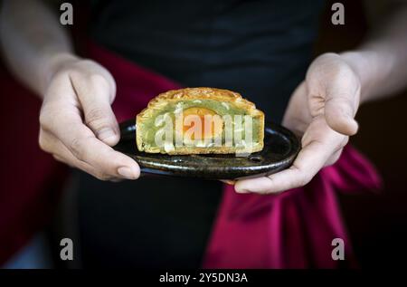 Die Kellnerin serviert traditionelle chinesische, festliche Mooncake-Gebäck-Dessert Stockfoto