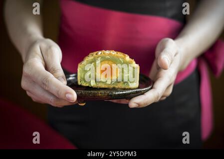 Kellnerin serviert traditionelle chinesische Gourmet-Mooncakes festliche süße Speisen aus der Nähe Stockfoto