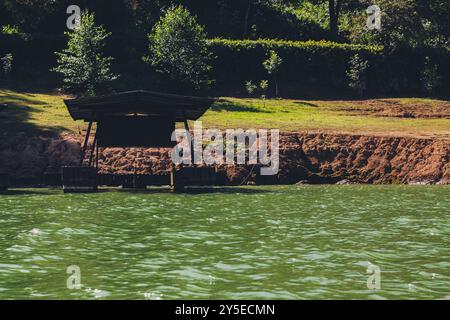 Ruhiges Wasser mit einem Ruhesitz am Ufer Stockfoto