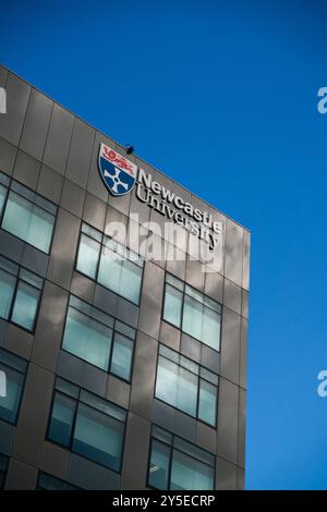 Allgemeine Ansicht eines Gebäudes der Newcastle University mit dem Logo und Wappen der Newcastle University als Schild an einem sonnigen Tag. Stockfoto