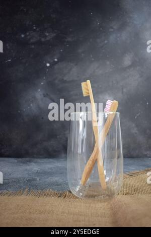 Zwei Bambuszahnbürsten in einem Glasbecher. Stockfoto