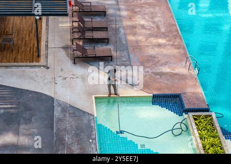 Arbeiter, der einen Kinderpool putzt, Blick von oben. Poolpflege und -Pflege. Stockfoto