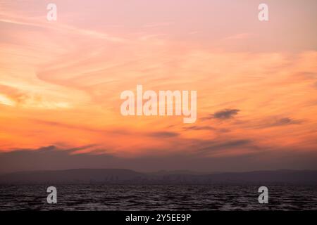 Die Sonne untergeht über Wales, vom Weston-super-Mare Beach in Somerset aus gesehen. Stockfoto