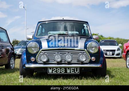 Ein dunkelblauer Mini Cooper mit Nebellichtern, der an einem sonnigen Tag bei einer Autoshow in Weston-super-Mare, North Somerset, geparkt wurde. Der Mini ist ein W-Registrierungsmodell, das 2000 registriert wurde. Stockfoto