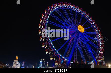 München, Deutschland. September 2024. Das Riesenrad wird auf dem Oktoberfest farbenfroh beleuchtet. Die Wiesn findet vom 21. September bis 6. Oktober 2024 statt. Quelle: Stefan Puchner/dpa/Alamy Live News Stockfoto