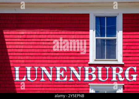 Lunenburg-Schild mit weißer Schrift auf einem farbenfrohen roten Holzhaus, Altstadt von Lunenburg, Nova Scotia Stockfoto