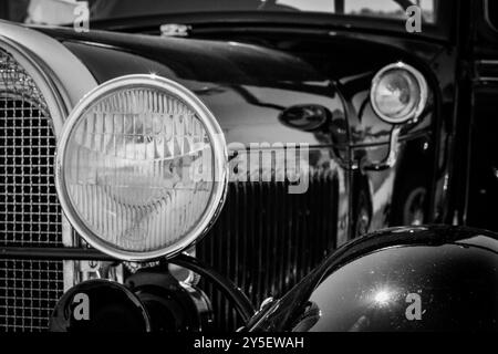 Eine Nahaufnahme zeigt die Vorderseite eines Oldtimer-Autos von Ford Model A und hebt den markanten Scheinwerfer und den glänzenden Kühlergrill hervor. Stockfoto