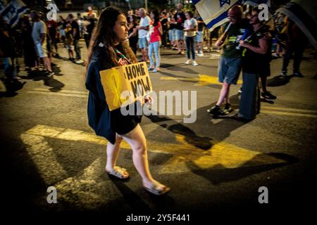 Tel Aviv, Israel. September 2024. Eine Frau hält ein Schild, während sie während einer Kundgebung in Tel Aviv am Samstag, 22. September 2024, läuft. Zehntausende Israelis demonstrierten am Samstagabend in Tel Aviv und in ganz Israel, um einen Waffenstillstand zu unterstützen, der die Freilassung von Geiseln ermöglichen soll, die seit dem 7. Oktober von der Terrorgruppe der Hamas in Gaza gefangen gehalten wurden. Verwandte sagen, dass Netanjahu die hostagesÕ opfert, während sich die Nordfront ohne Geiselstillstandsabkommen mit der Hamas erhitzt. Foto von Eyal Warshavsky. Quelle: Eyal Warshavsky/Alamy Live News Stockfoto