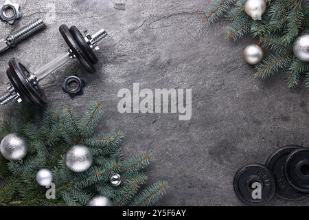 Barbell, Hantelteile und Weihnachtsdekor auf grauem Hintergrund, flache Lagen. Leerzeichen für Text Stockfoto